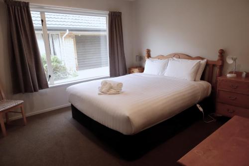 a bedroom with a bed with a stuffed animal on it at Handy Location, Ocean & Mountain Views, Close to Park - KK96845 in Kaikoura
