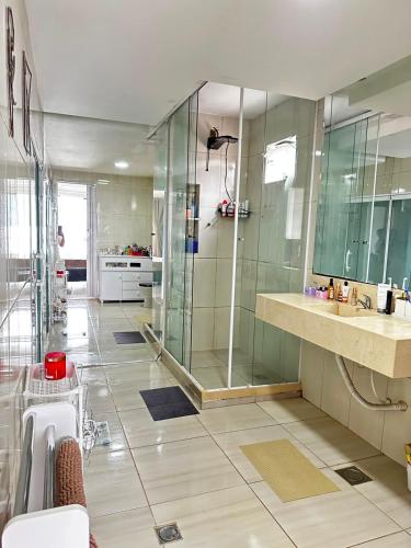 a bathroom with a shower and two sinks and a glass shower stall at Meneghetti Mangaratiba in Mangaratiba