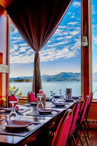 a long table with chairs and a view of the water at Sol del Nahuel - Hotel Boutique & Spa in San Carlos de Bariloche