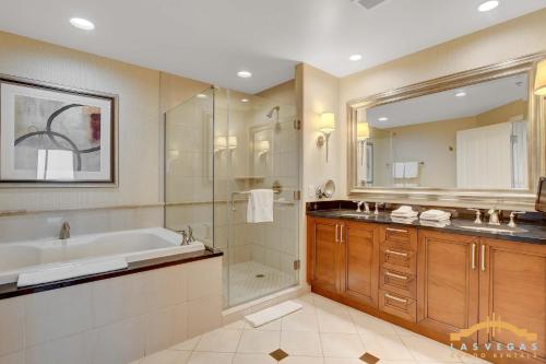 a bathroom with a tub and a shower and a sink at Deluxe Spa 24th floor Signature Studio with Mountain View in Las Vegas