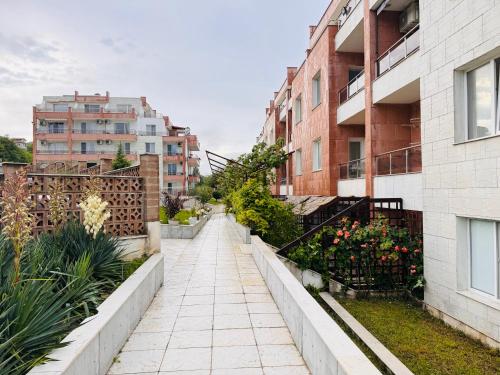 a walkway in a city with buildings and plants at Kiwi Gardens in Byala