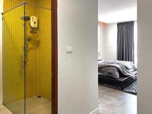 a bathroom with a shower with a yellow tile wall at LECAR Home Mustang in Ban Nong Khang