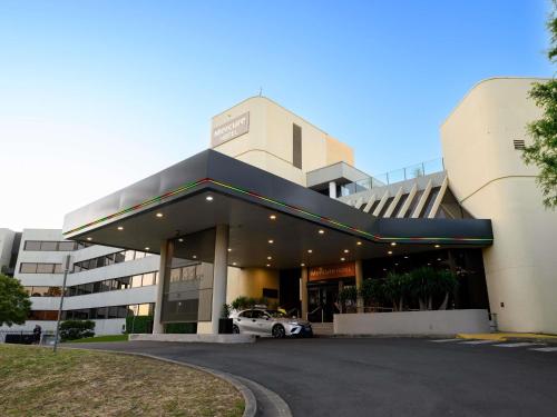 a building with a car parked in front of it at Mercure Penrith in Penrith