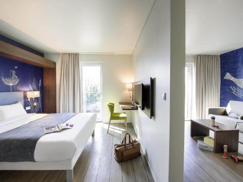 a hotel room with a bed and a desk at Ibis Styles Konstanz in Konstanz