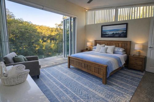 a bedroom with a bed and a large window at Fishers Villa - Crescent Head in Crescent Head