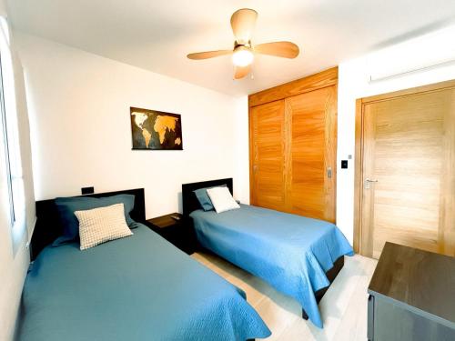 a bedroom with two beds and a ceiling fan at Estrella Garden Condos con Vista a la piscina in San Rafael del Yuma