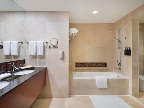 a bathroom with a tub and a sink at Grand Mercure Singapore Roxy in Singapore