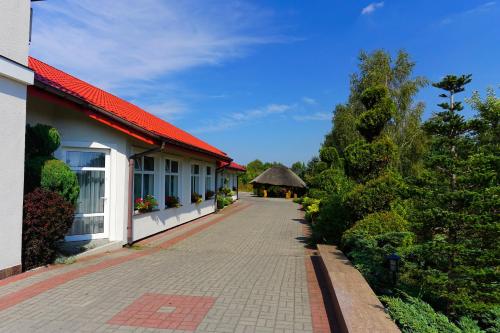 a walkway next to a building with a red roof at Laura in Bełchatów