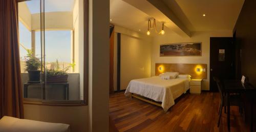 a bedroom with a bed and a large window at Hotel Miramar in Huarmey