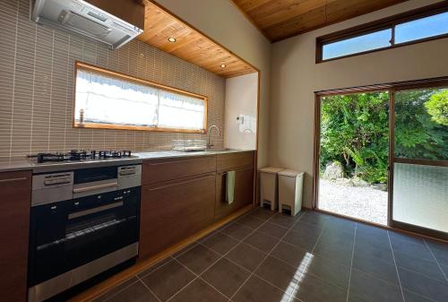 a kitchen with a stove and a sink and a window at 館山ガーデンヴィラ 宮城ハウス - 平屋一棟貸し 屋根付きBBQ ペットok in Tateyama