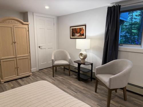 a bedroom with two chairs and a table and a window at Sunset Suite in Bridgewater