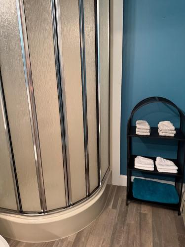 a bathroom with a shower with towels on a shelf at Sunset Suite in Bridgewater