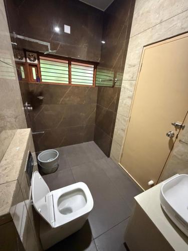 a bathroom with a toilet and a sink at Bodhi nila private villa in Irimbranallūr
