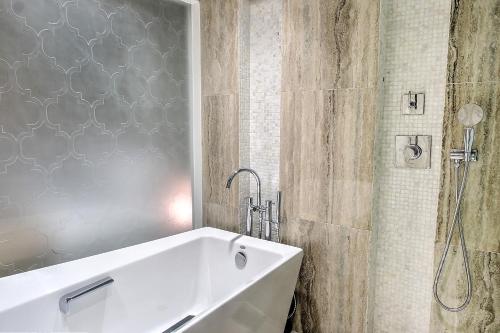 a white tub in a bathroom with a shower at LeoPalace Resort Guam in Yona