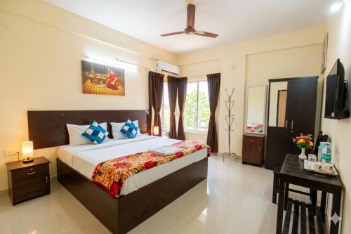a bedroom with a bed and a television in it at Classique Inn Near Padmanabhaswamy Temple in Trivandrum