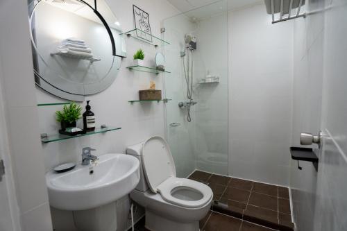a bathroom with a toilet and a sink and a mirror at KL Tower Luxury Boutique Hotel Studio Fast WiFi Resort Swimming Pool Sauna & Gym in Manila