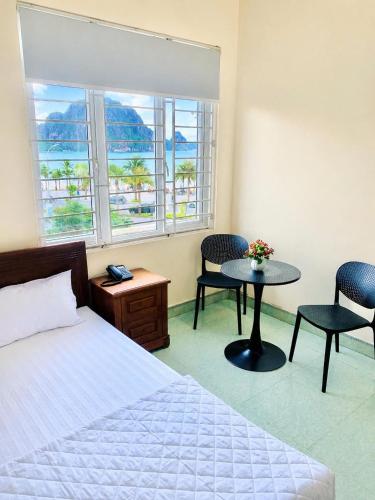 a bedroom with a bed and a table and two chairs at Sao Mai Hotel Hạ Long in Ha Long