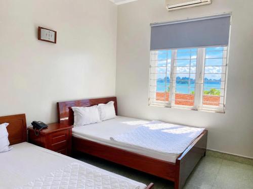 a bedroom with two beds and a window at Sao Mai Hotel Hạ Long in Ha Long