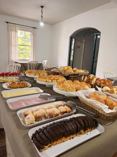 a table with many different types of pastries on it at Hotel Montanas in Nova Friburgo