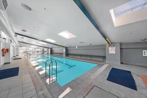 a large swimming pool in a building at Stylish 2-Bed Stay with Pool & Parking in Canberra