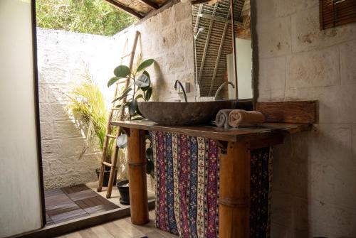 a bathroom with a sink and a mirror at Vertical House Bali in Uluwatu