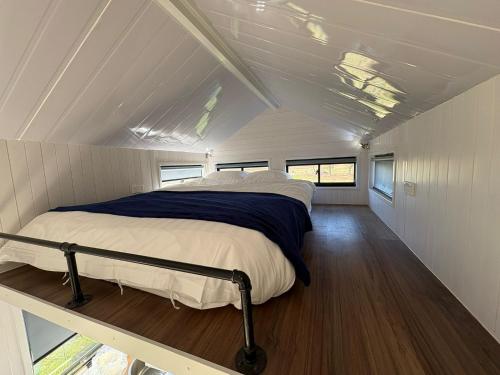 a bed in the middle of a small bedroom at Loft Tiny House by Tiny Away in Banyena