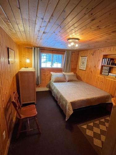 a bedroom with a large bed in a wooden room at Pine Haven in Mercer