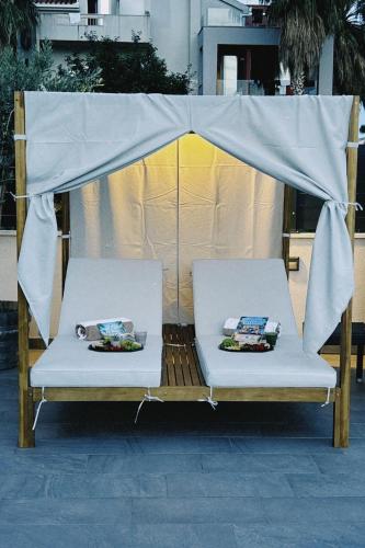 two white chairs sitting under a canopy at Beach Hotel Božikovina in Podstrana