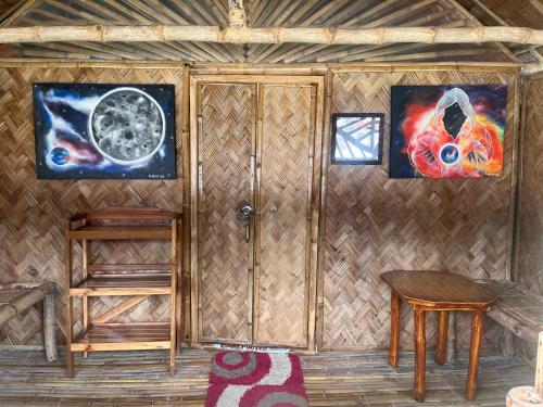 a room with a wooden wall with a table and a window at Bamboo Nest Beachfront in Puerto Princesa City