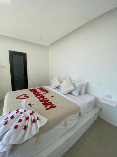 a white bedroom with a bed with a blanket on it at Rumah pinggan private pool in Kubupenlokan