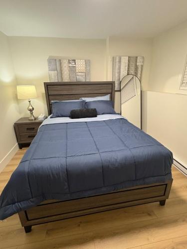 a bedroom with a large bed with a blue comforter at Lovely Two-Bedroom APT at Kenmount Terrace in St. John's