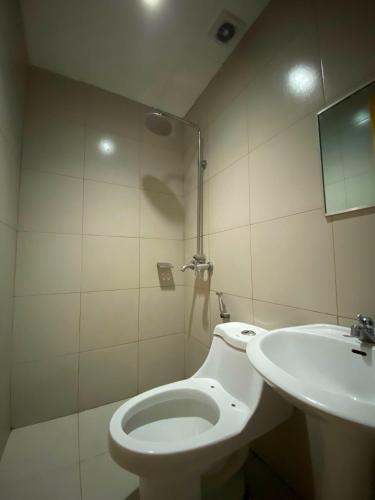 a bathroom with a toilet and a sink at Nice Hotel Arayat Cubao in Manila