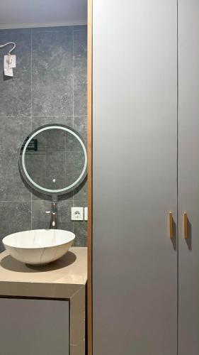 a bathroom with a sink and a mirror at Rdm Bali Guest House in Badung