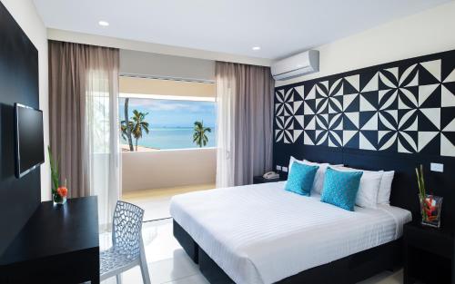 a bedroom with a bed and a view of the ocean at Tanoa International Dateline Hotel in Nuku‘alofa