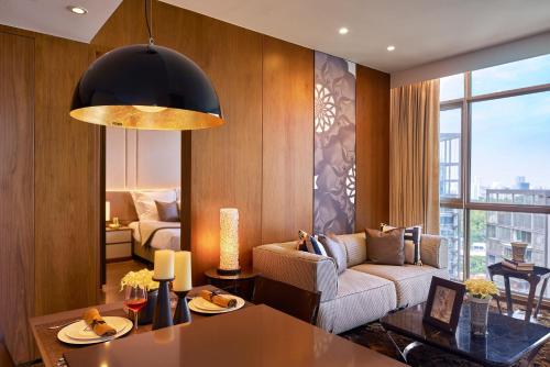 a living room with a couch and a table at Ascott Orchard Singapore in Singapore