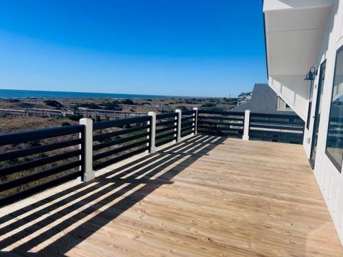 a wooden deck with a view of the ocean at Somewhere South home in Holden Beach