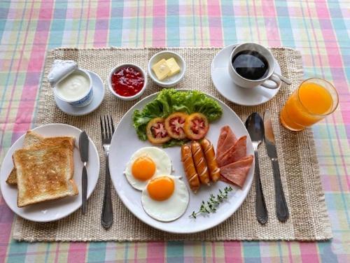 a plate of breakfast food with eggs bacon and toast at Ayothaya Riverside Hotel in Phra Nakhon Si Ayutthaya