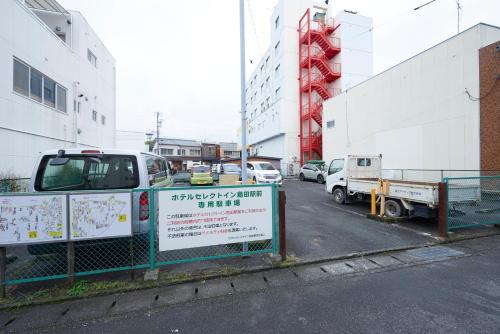 a sign on a fence in a parking lot at Select Inn Shimada Ekimae in Shimada