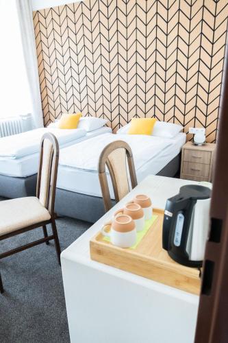 two beds in a room with a table and chairs at hotel Dobruška in Dobruška