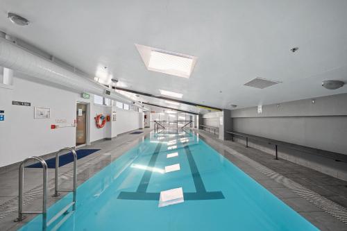 a large swimming pool in a building at City-Edge 1-Bed Apartment with Pool Access in Canberra