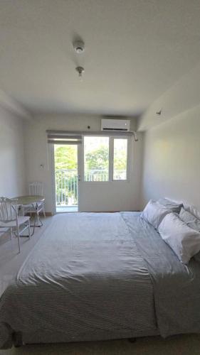 a bedroom with a large bed and a table at Mattys Crib Tower C Unit 204 in Iloilo City