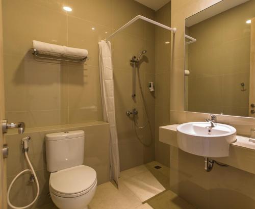 a bathroom with a toilet and a sink and a shower at Sparks Odeon Sukabumi, ARTOTEL Curated in Sukabumi