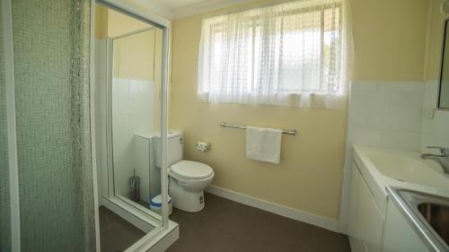 uma casa de banho com um WC, um lavatório e um chuveiro em Jadon Place Holiday Apartments em Gold Coast