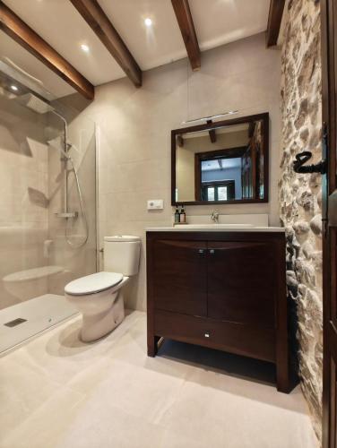 a bathroom with a toilet and a sink and a mirror at El Refugio de Júlia in Mier