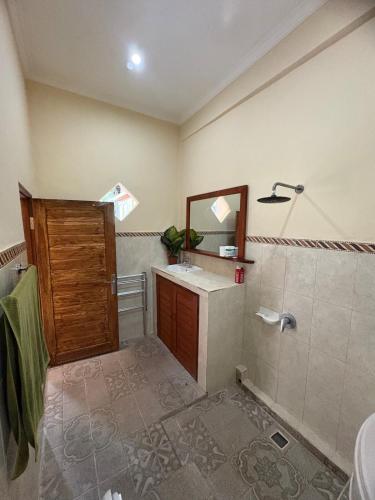 a bathroom with a shower and a sink and a mirror at Dede House 1 Private Pool in Ubud
