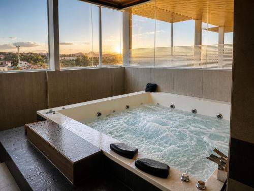 a large bath tub in a room with windows at Tarija Premium Stay Apartamento Premium in Tarija