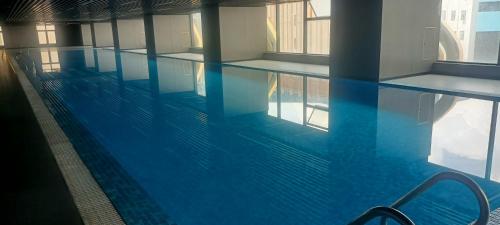 a swimming pool with a chair in a building at CondoApsara in Phnom Penh