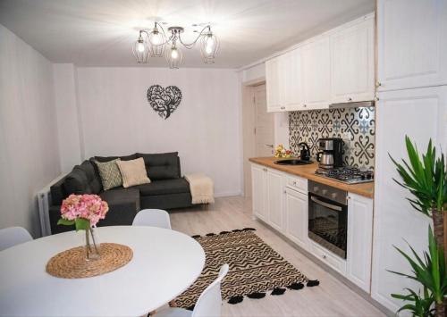 a kitchen and living room with a table in a room at Apartament Daria in Târgu Ocna