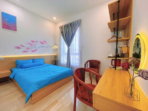 a bedroom with a blue bed and a table at Mie's Homestay in Danang