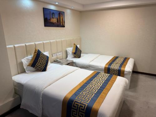 a hotel room with two beds in a room at Sayohat Hotel in Tashkent